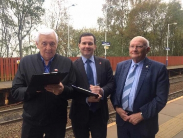 Bolton West MP Chris Green, centre, with a resident signing the petition and chair of The Bridge at Dorset Road Community Centre Norman Bradbury at Hagfold railway station